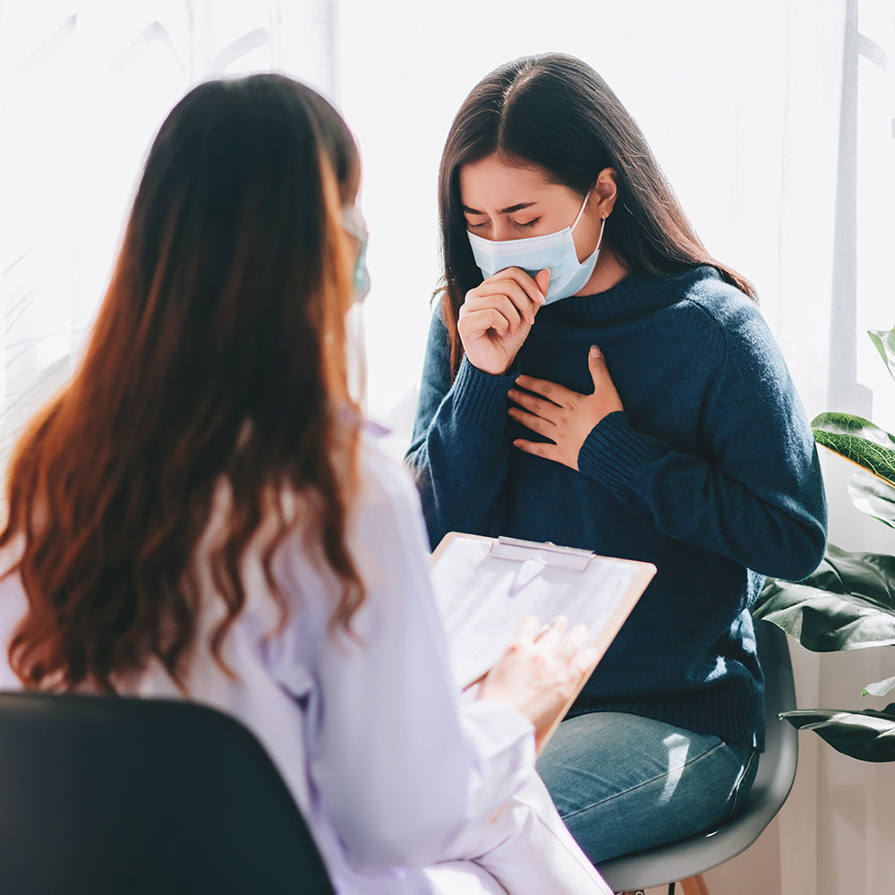 Sick patient coughing whilst doctor does examination.