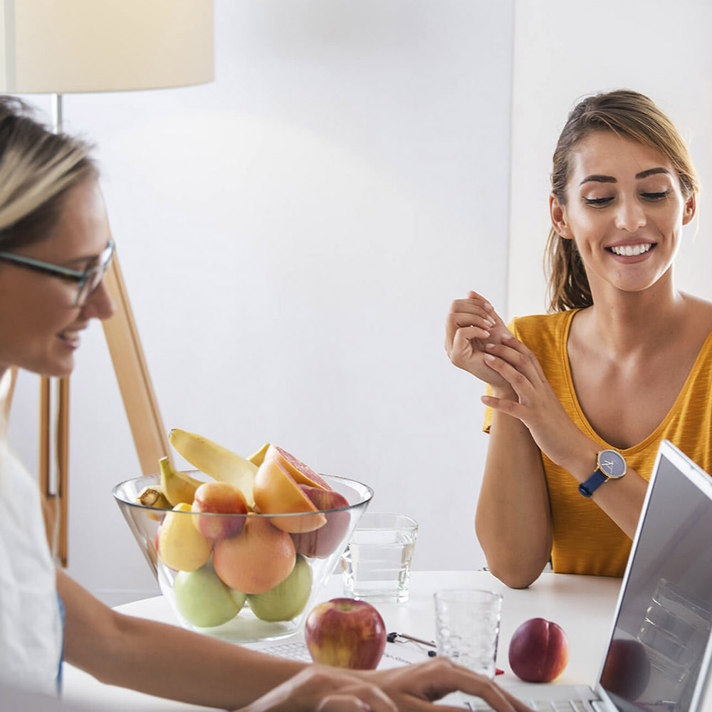 Dietician and female patient having a discussion at a table.