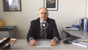 Video thumbnail image of a male doctor sitting at his desk.